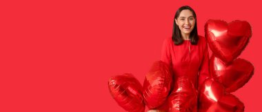 Güzel, genç bir kadın ve kırmızı arka planda kalp şeklinde balonlar ve metin için yer var. Sevgililer Günü kutlaması