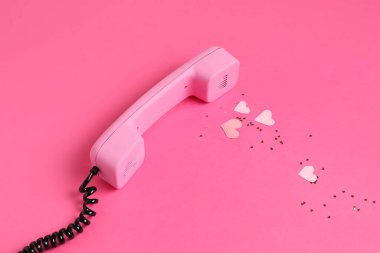 Kağıt kalpli Retro telefon ve pembe arka planda konfeti