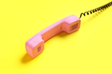 Sarı arka planda pembe retro telefon ahizesi