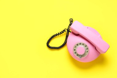 Sarı arkaplanda pembe retro telefon