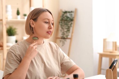 Tuvalette yüz masajı yapan bir kadın.