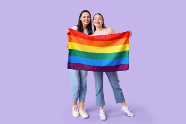 Leylak arka planında LGBT bayrağı olan güzel bir lezbiyen çift.