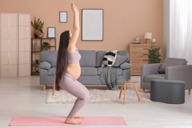 Evde egzersiz yaparak güzel bir hamile kadın