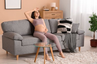 Evdeki koltukta antrenman yaptıktan sonra hamile bir kadın yorgun düştü.