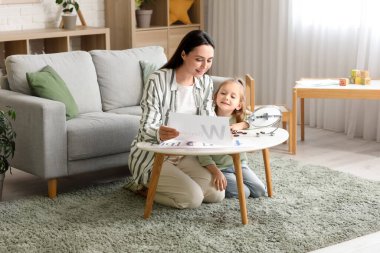 Ofiste küçük bir kızla çalışan kadın konuşma terapisti.