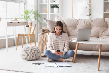 Evde çalışan farklı aletler ve panolarla güzel, genç, mutlu bir kadın.