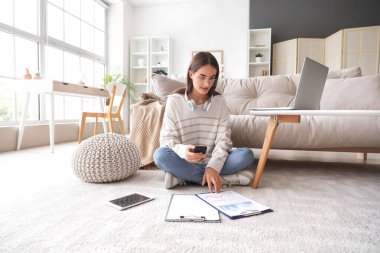 Evde çalışan farklı aletler ve panolarla güzel, genç, mutlu bir kadın.