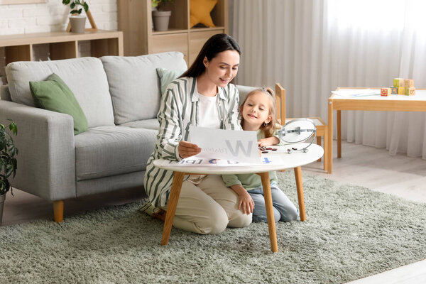 Женский логопед, работающий с маленькой девочкой в офисе