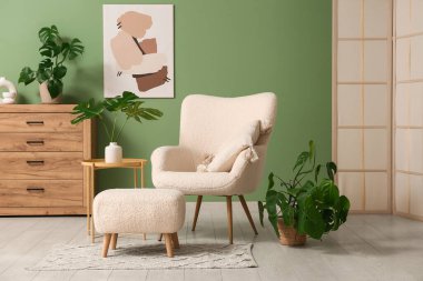 Masada ve şık koltukta tropikal canavar yaprakları olan modern bir oturma odası.