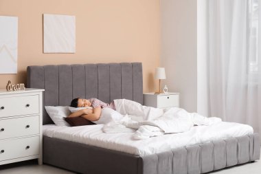 Güzel genç bir bayanın rahat bir yatakta uyuduğu bir sabah.