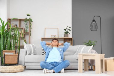 Yakışıklı genç adam evde kliması açık dinleniyor.