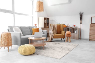 Koltuğu, kanepesi ve balkabağı olan bir oturma odası.