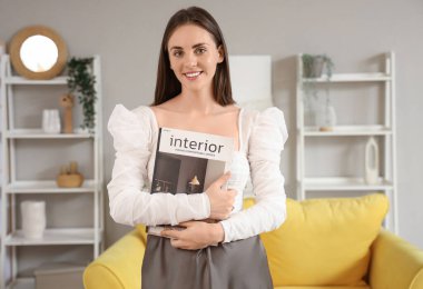 Evde dergisi olan güzel genç bir kadın.