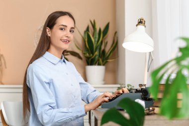 Masada oturan daktilolu güzel, mutlu kadın yazar.