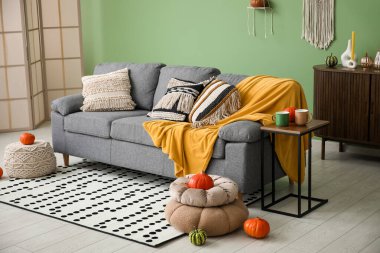 Gri koltuklu, puf, balkabağı ve ekoseli salonun sonbahar içleri.