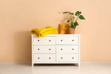 Çekmeceli ve sarı örülü ekose kumaşlı modern oturma odası.