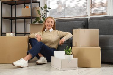 Taşınma gününde ofisinde kutuları olan olgun bir iş kadını.