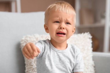 Sevimli erkek bebek evde ağlıyor, yakın plan.