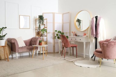 Soyunma masası ve ev bitkileriyle aydınlatma odasının şık bir iç mekanı.