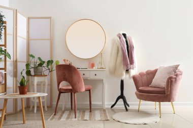 Soyunma masası ve ev bitkileriyle aydınlatma odasının şık bir iç mekanı.