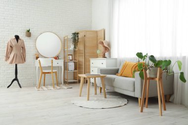 Rahat kanepesi ve tuvalet masası olan şık bir aydınlatma odası.