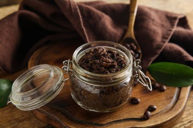 Tepsiyle kompozisyon, kavanoza konan kahve bedeni ve ahşap arka planda peçete, yakın plan.