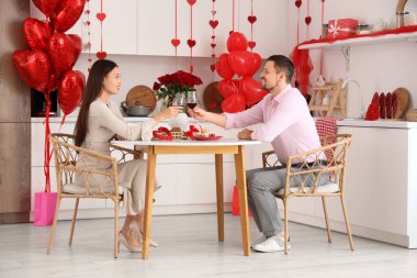 Sevgililer Günü 'nde mutfakta şarap içen genç bir çift.