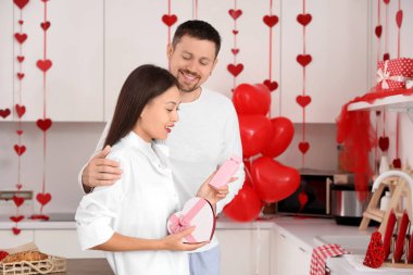 Sevgililer Günü 'nde kocasından hediye parfümü almış genç bir Asyalı kadın.