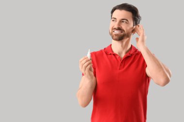 Arka planda kulak damlası olan genç bir adam.