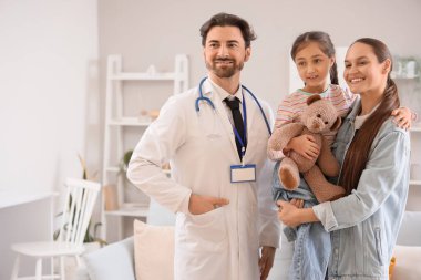 Erkek çocuk doktoru ve annesi kızıyla birlikte evde.