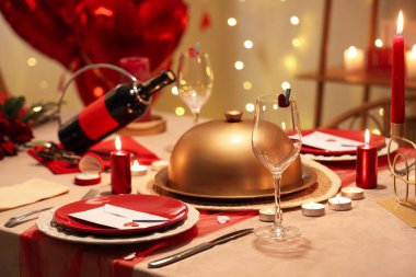 Sevgililer Günü için masa ayarı. Parlayan ışıklar ve kalp şeklinde balonlarla dolu.