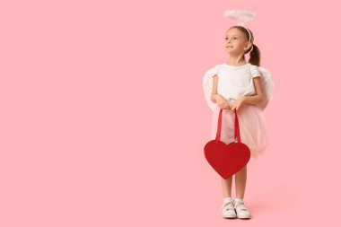 Aşk tanrısı gibi giyinmiş, pembe arka planda kalp şeklinde çantası olan tatlı küçük bir kız. Sevgililer Günü kutlaması