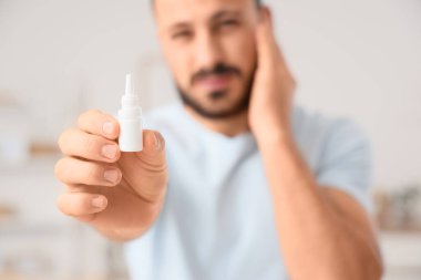 Evde kulak ağrısı çeken genç bir adam, yakın plan.