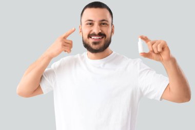 Arka planda kulak damlası olan genç bir adam.