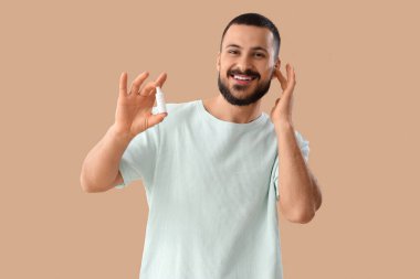 Bej arka planda kulak damlası olan genç bir adam.