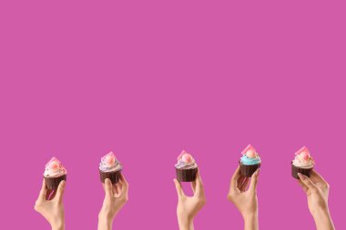 Mor arka planda doğum günü kekleri olan birçok kadın eli.