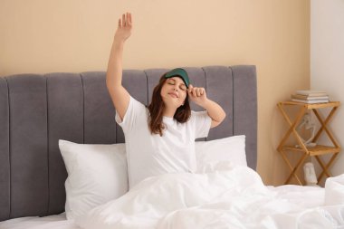 Güzel genç bir kadın sabahları yatakta geriniyor.