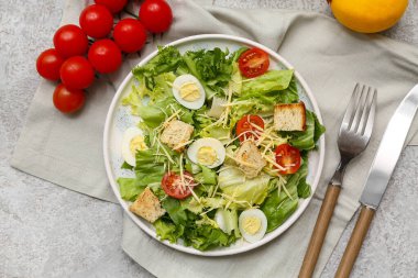 Lezzetli Sezar salatası, domates ve limonlu gri arka plan.