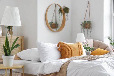 Yatak odasının içinde rahat bir yatak ve bitkiler.