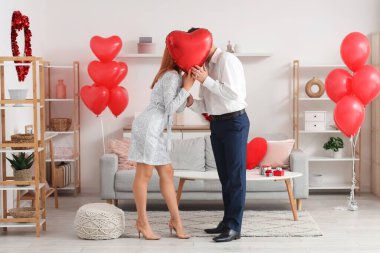 Evde balon şeklinde öpüşen genç ve güzel bir çift. Sevgililer Günü kutlaması