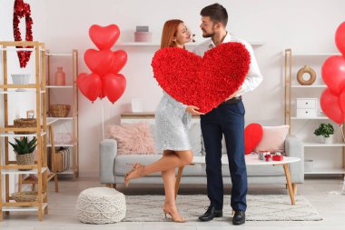 Evinde dekoratif kalbi olan genç ve güzel bir çift. Sevgililer Günü kutlaması