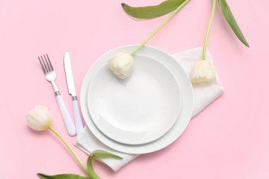 Pembe arka planda güzel lale çiçekleri olan şık masa ayarı