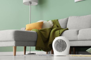 Modern elektrikli fan ısıtıcısı şık oturma odasında yerde.
