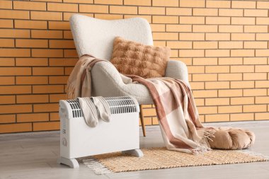 Modern konveksiyon ısıtıcısı ve rahat beyaz koltuğu olan şık bir oturma odası.