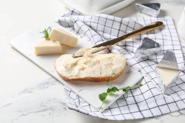 Lezzetli işlenmiş peynir, bıçak ve peçeteyle bir dilim ekmek.