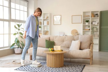 Evde tartıyla ağırlığını ölçen genç bir kadın. Keto diyet kavramı