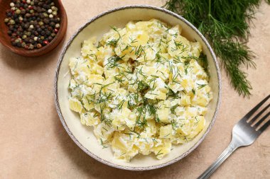 Bej rengi grunge arkaplanda dereotlu ve biberli patates salatası.