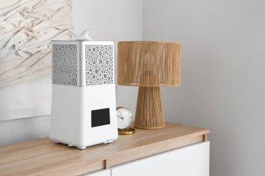 Çalar saat ve lambayla modern hava nemlendiricisi yatak odasında klozette.