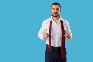 Mavi arka planda kravatlı genç iş adamı