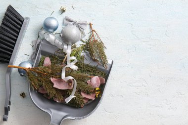 Kırık Noel süslemeleri olan faraş, kuru köknar dalları ve arka planda temizlik fırçası